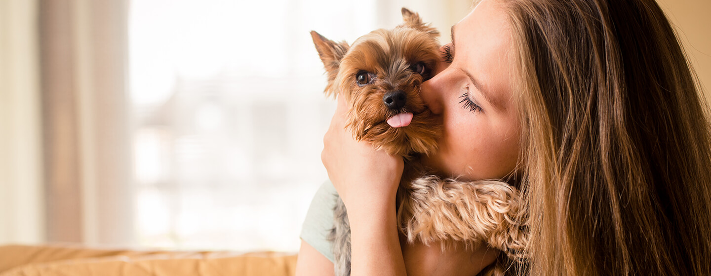 Frau kuschelt mit kleinem Hund