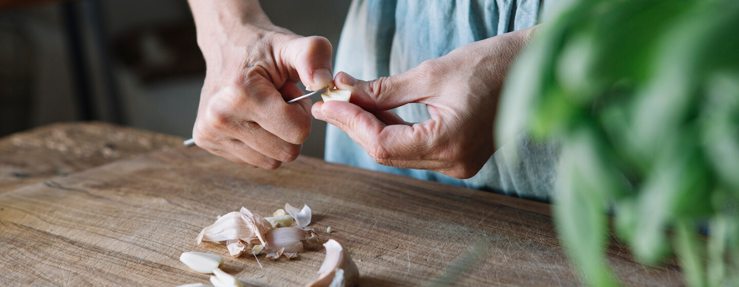 Frau schält Knoblauch