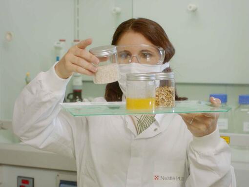 Wissenschaftlerin betrachtet Zutaten in Töpfen